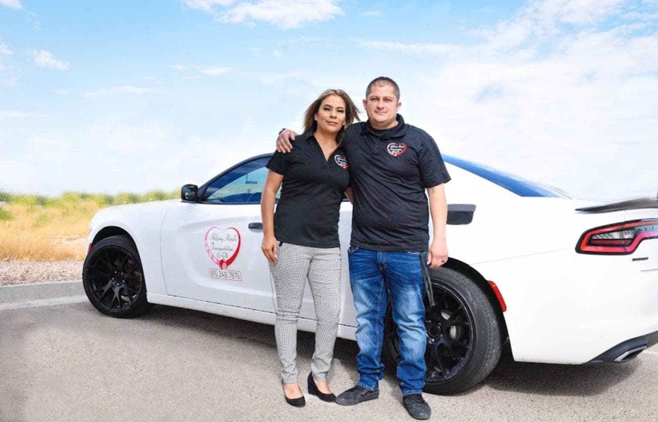 Photo of Karina, owner of Helping Hands Transportation, standing beside her company vehicle